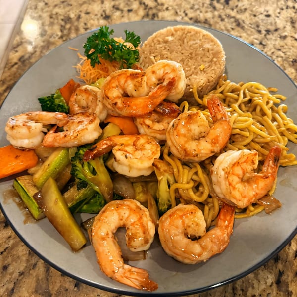 A plate of Juicy Seafood Mayport shrimp, noodles, fried rice, and mixed vegetables.